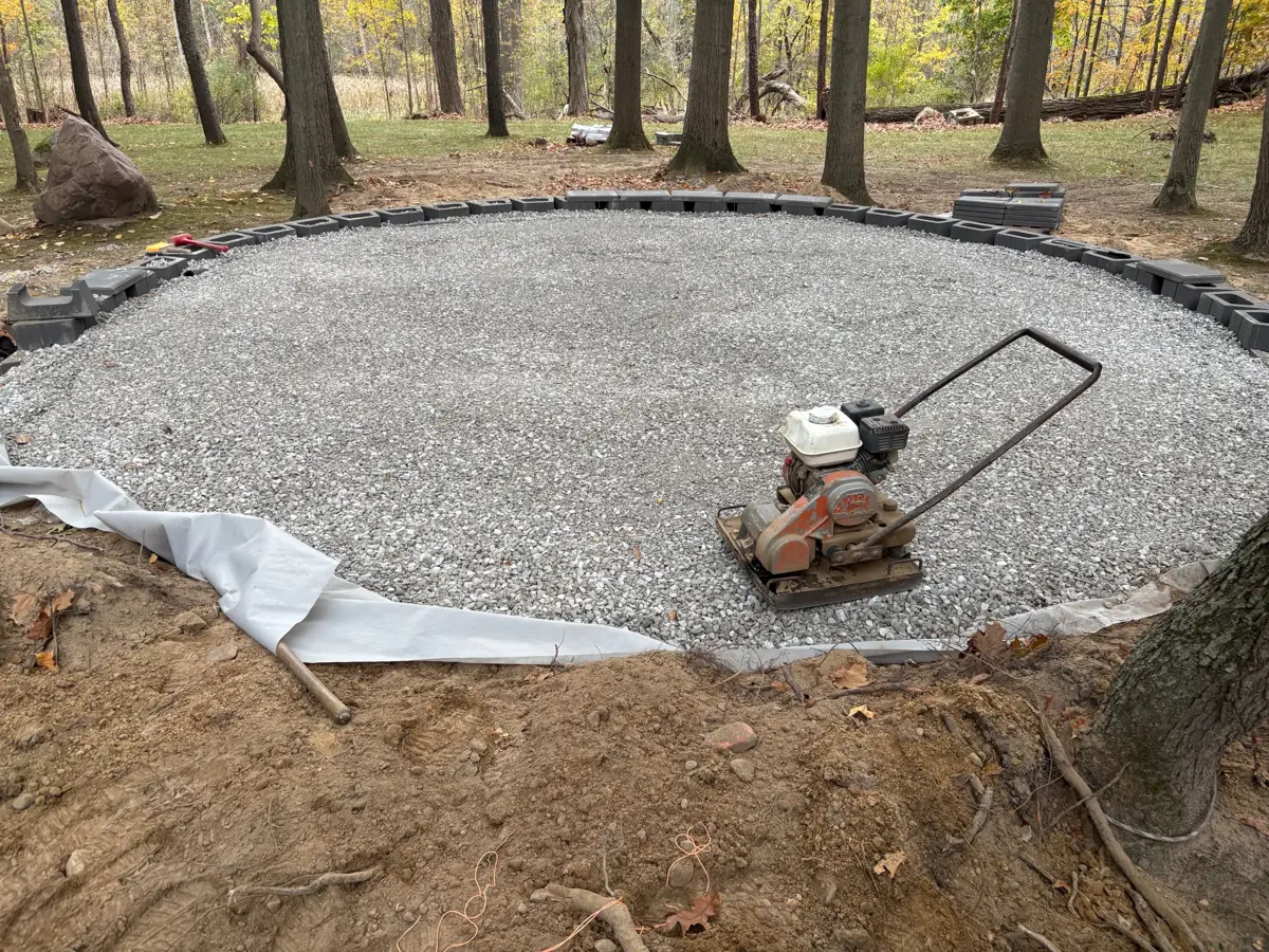 Compacted gravel base with fabric and edge blocks for a paver patio
